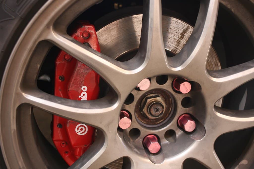 Red six-piston caliper behind a lightweight wheel